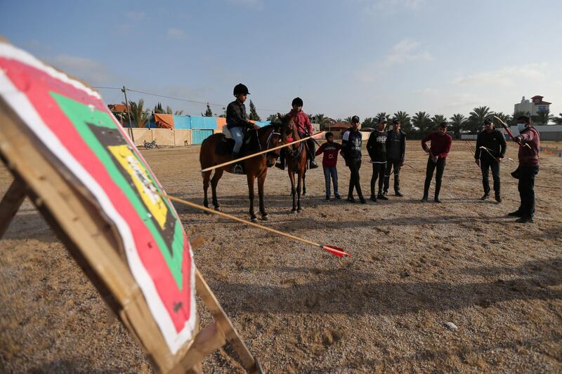 Palestinian coach Mohammad Abu Musaed shoots an arrow at a target as he instructs his team during a training session in Zawayda in the central Gaza Strip. Reuters
