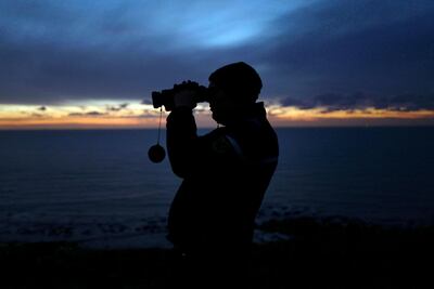 FILE - In this file photo dated Friday, Jan. 18, 2019, a French gendarme patrols the beach in Ambleteuse near Calais, northern France.  Fifteen migrants have been saved Tuesday Oct. 27, 2020, and rescue and search operations are still under way, but at least four migrants, including a 5-year-old and 8-year-old child, have died Tuesday when their boat capsized while they and other migrants tried to cross the English Channel to Britain, French authorities said. (AP Photo Michel Spingler, FILE)