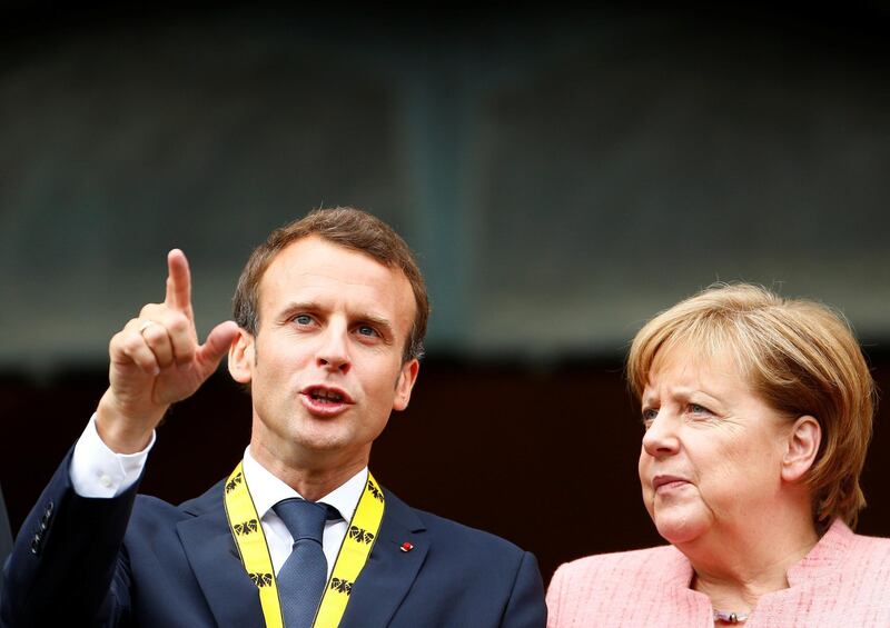 FILE PHOTO: French President Emmanuel Macron speaks to German Chancellor Angela Merkel after being awarded the Charlemagne Prize during a ceremony in Aachen, Germany May 10, 2018. REUTERS/Thilo Schmuelgen/File Photo