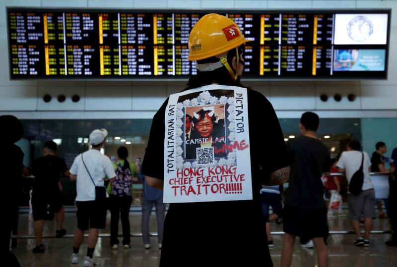 A demonstrator wears a placard during a protest against the recent violence in Yuen Long, at Hong Kong airport, China July 26, 2019. REUTERS/Edgar Su         TPX IMAGES OF THE DAY