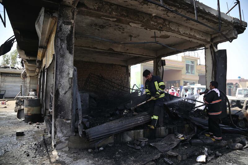 Firefighters inspect the scene of the suicide bomb attack. EPA