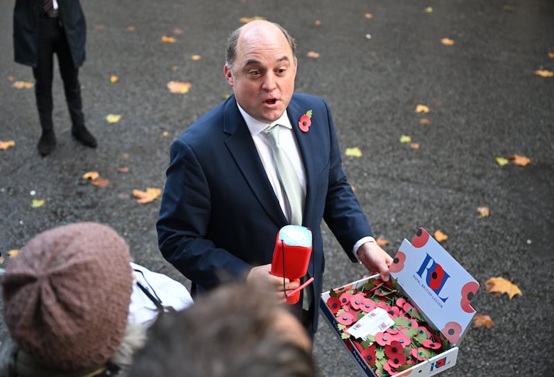 Mr Wallace sells poppies to members of the media as he leaves a Cabinet meeting in Downing Street in November. Getty Images