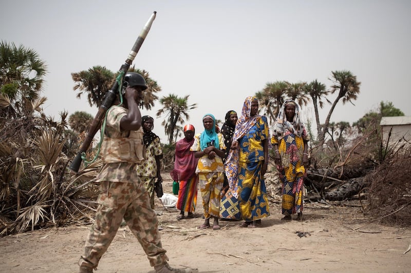 A Nigerian soldier, with a rocket propelled grenade (RPG), patrols on the outskirt of the town of Damasak in North East Nigeria on April, 25 2017 as thousands of Nigerians, who were freed in 2016 by the Nigerian army from Boko Haram insurgents, are returning to their homes in Damasak. - Yagana Bukar's younger brothers Mohammed and Sadiq were among about 300 children kidnapped by Boko Haram from the town of Damasak in remote northeastern Nigeria nearly three years ago. But instead of the global outrage and social media campaign that followed a similar abduction of 219 schoolgirls from the town of Chibok, there were no protests for the children of Damasak. (Photo by Florian PLAUCHEUR / AFP)