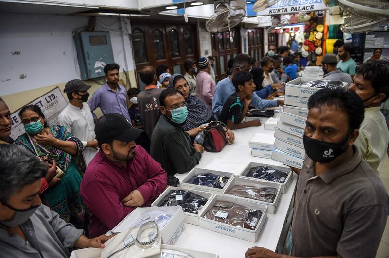 People gather for shopping at a market after the government eased a nationwide lockdown imposed as a preventive measure against the COVID-19 coronavirus, in Karachi on May 13, 2020.
 / AFP / Rizwan TABASSUM
