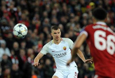 Roma's Edin Dzeko, left, kicks the ball during the Champions League semifinal, first leg, soccer match between Liverpool and Roma at Anfield Stadium, Liverpool, England, Tuesday, April 24, 2018. (AP Photo/Rui Vieira)