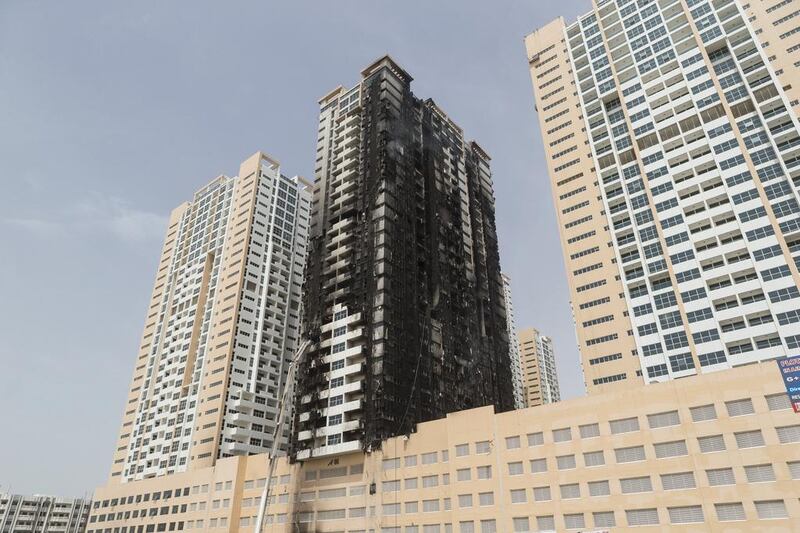 The badly damaged outside of Tower Eight at the Ajman One development where the fire started before spreading to other buildings nearby. Antonie Robertson / The National