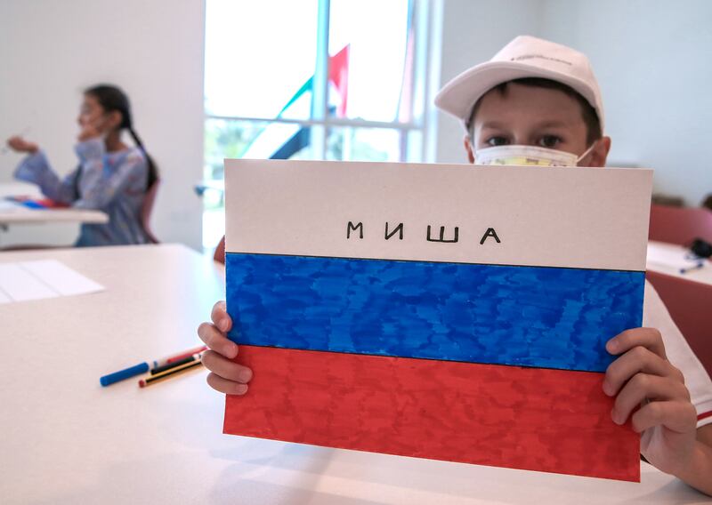 A pupils draws the Russian national flag in art class.