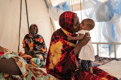 Jamia Ishak Osman kisses her child at a malaria clinic at the Adre refugee camp in Chad. The conflict in Sudan has displaced nearly six million of its estimated 48 million population. Getty Images.