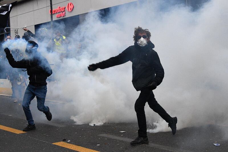 Protesters, surrounded by tear gas, throw back canisters during a demonstration.  AFP
