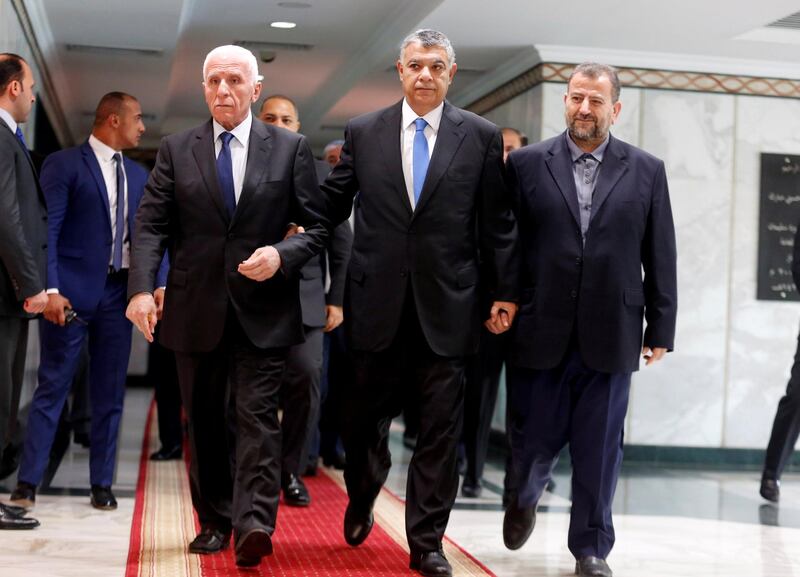 Egyptian intelligence chief Khaled Fawzi (C) walks with head of Hamas delegation Saleh Arouri and Fatah leader Azzam Ahmad as they sign a reconciliation deal in Cairo, Egypt, October 12, 2017. REUTERS/Amr Abdallah Dalsh