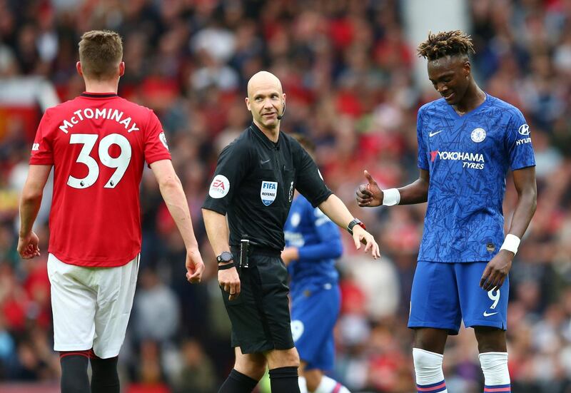 Manchester United's Scott McTominay, left, walks past as Chelsea's Tammy Abraham, right, gives thumbs up to referee Anthony Taylor. AP Photo