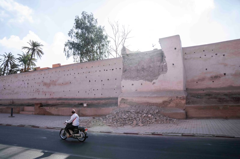 A man drives past a damaged wall of the historic Medina of Marrakesh. AP Photo