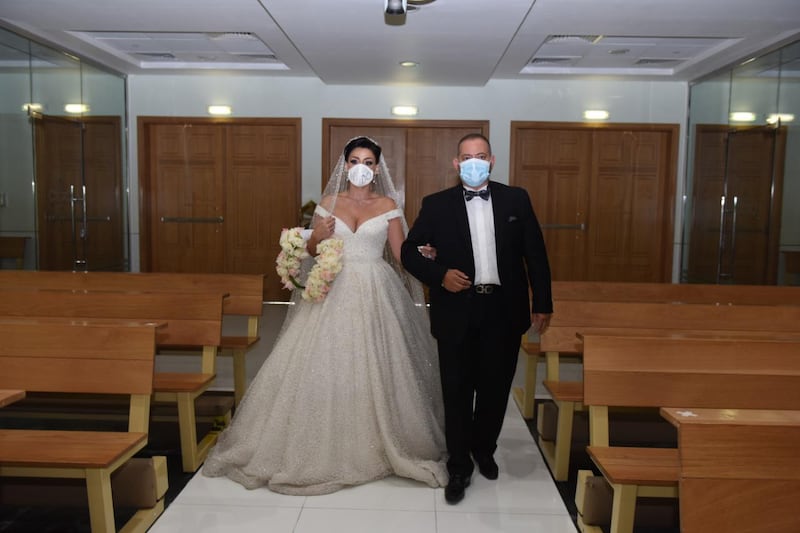 Laura Daher walks down the aisle with her brother George. She married Elie Abi Daher in a quiet ceremony with only eight guests at the St Therese Church in Abu Dhabi. Laura Daher and Elie Abi Daher