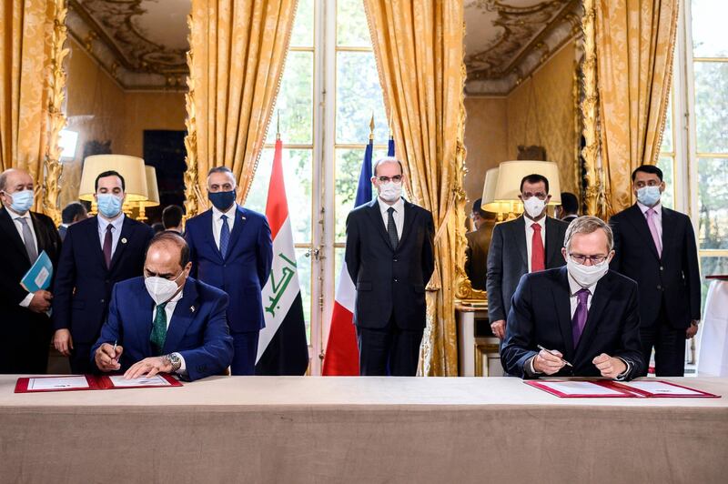 French Prime Minister Jean Castex and Iraqi Prime Minister Mustafa al-Kadhimi look on as CEO of Alstom Henri Poupart-Lafarge and Iraqi Transport Minister  Nasser Hussain Al-Bandar sign documents during a contracts and economic agreements signing ceremony at the Hotel de Matignon in Paris.  AFP