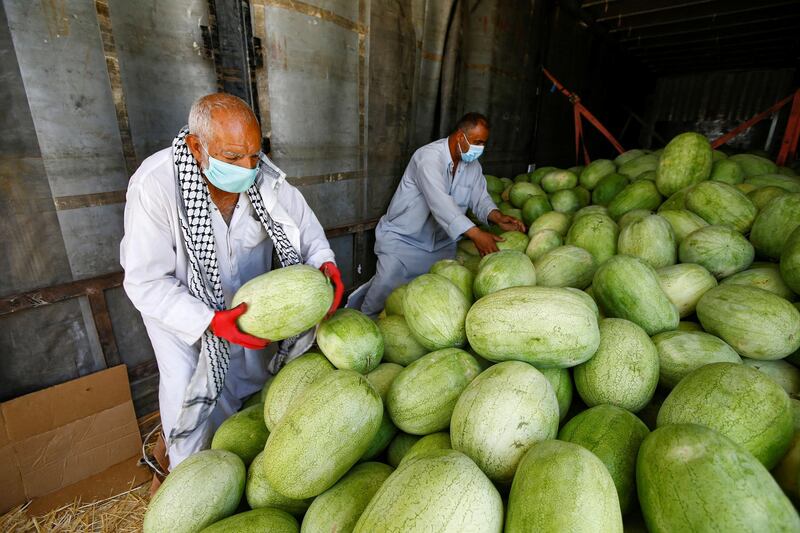 Iraqi men sell watermelons at a market in the city of Najaf, Iraq. Reuters