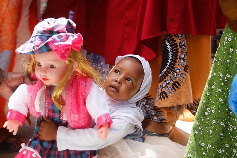 A girl carries a doll in a street market in Mogadishu, Somalia, as preparations are made for the Muslim holiday of Eid al-Fitr. AP Photo