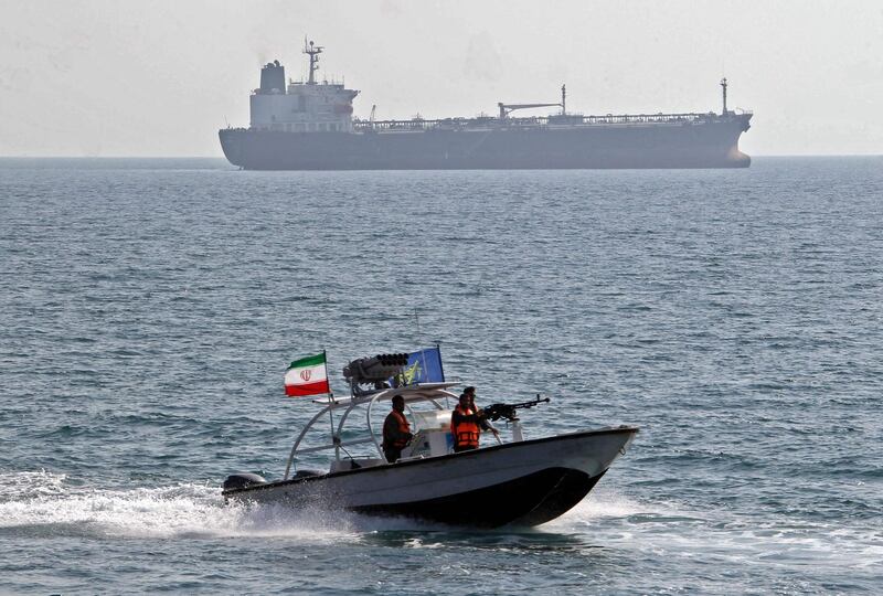(FILES) In this file photo taken on July 2, 2012, members of Iran's Islamic Revolutionary Guard Corps (IRGC) ride in a speed boat in front of an oil tanker during a ceremony to commemorate the 24th anniversary of the downing of Iran Air flight 655 by the US navy, at the port of Bandar Abbas. Iran on September 16 seized a boat suspected of being used to smuggle fuel, and arrested its 11 crew members near the vital Strait of Hormuz oil shipping lane, state television reported. A naval patrol of the IRGC intercepted the vessel carrying 250,000 litres of fuel, state TV's website said, citing a commander of the force. / AFP / ATTA KENARE
