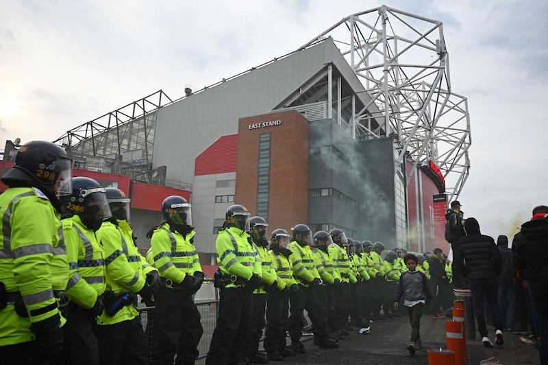 Police officers stand on duty as demonstrators protest against United's owners outside Old Trafford. AFP