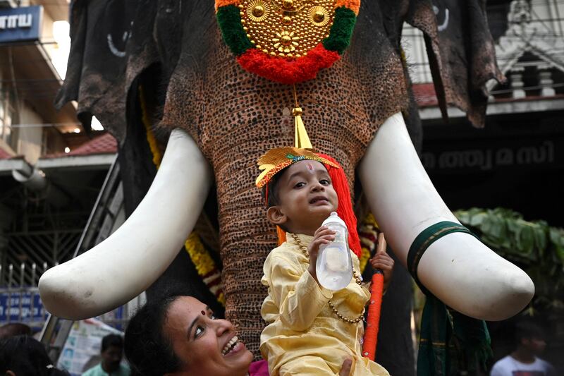 Dressing up time for little "Lord Krishna". Thankfully, the elephant is not real. AFP