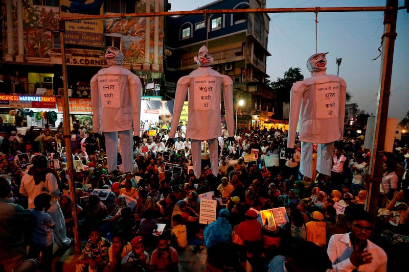 FILE - In this April 17, 2018 file photo, effigies hang on nooses with the words, from left to right, "hang the guilty in the Unnao rape case," "Hang the guilty in the Kathua rape case," and "hang the guilty in the Surat rape case," referring to recent cases and allegations of rape, during a protest in Ahmadabad, India. India's government has decided to prescribe the death penalty for people convicted of raping girls under the age of 12 to combat an increase in crimes against women. The Press Trust of India news agency reported Saturday, April 21, 2018, that the ordinance is being sent to the president for approval. It will require the approval of Parliament within six months in order the become law. (AP Photo/Ajit Solanki, File)