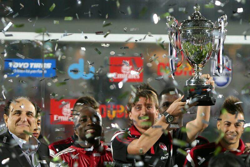 AC Milan’s captain Riccardo Montolivo raises a trophy after beating Real Madrid in their friendly football match on December 30, 2014 at the Sevens Stadium in Dubai. AFP PHOTO / MARWAN NAAMANI