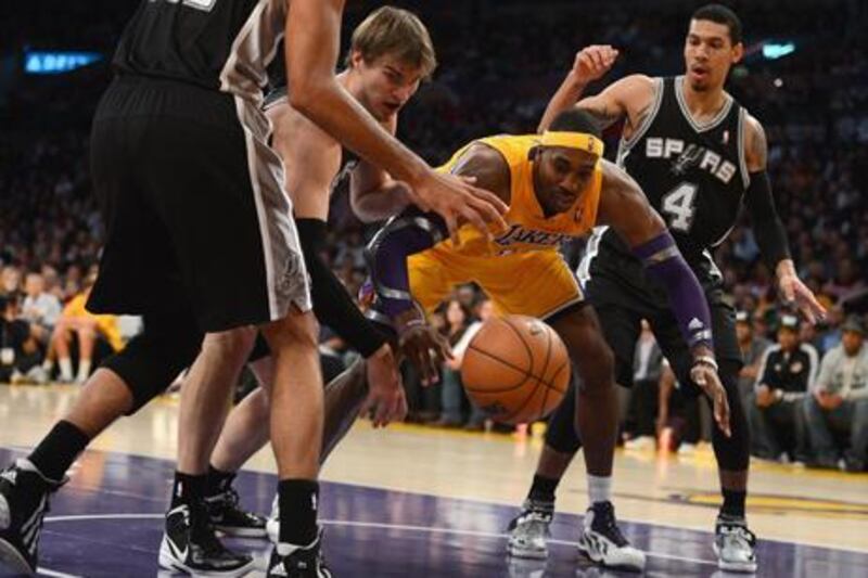 Los Angeles Lakers' Dwight Howard reaches for a rebound against San Antonio's Tiago Splitter and Danny Green