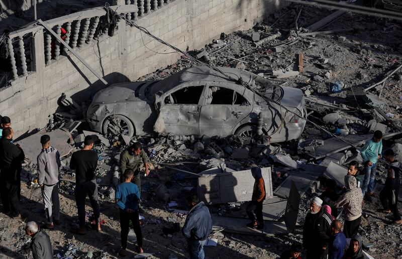 Palestinians inspect the damage at the site of an Israeli strike. Reuters