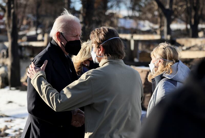 US President Joe Biden is embraced as he and first lady Jill Biden tour a fire ruins in Louisville, Colorado. Reuters