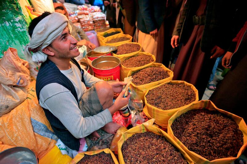 A dried fruit and nut merchant serves clients at an open-air market in Yemen's capital Sanaa.  AFP