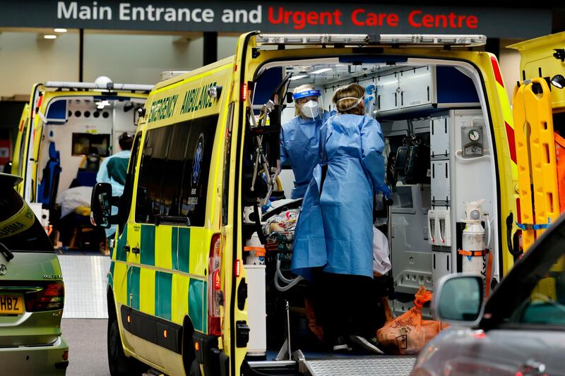 Paramedics prepare to remove a patient from an ambulance parked outside Guy's Hospital in London. AFP