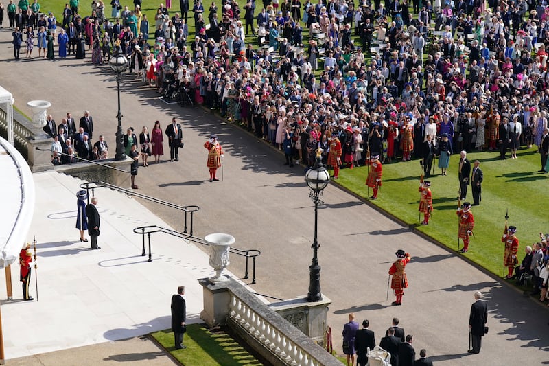 King Charles III and Queen Consort Camilla stand at the top of the Buckingham Palace steps before meeting guests at the garden party on May 3. AP
