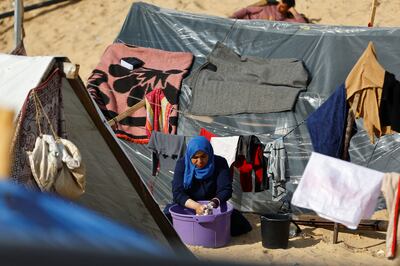A displaced Palestinian woman, who fled her house due to Israeli strikes, shelters at a tent camp in Rafah in the southern Gaza Strip. Reuters