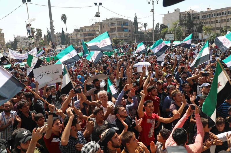 Men chant slogans and wave flags of the Syrian opposition during a demonstration against the government offensive in the northwestern Idlib province, in its capital of Idlib on September 6, 2019.  / AFP / Zein Al RIFAI
