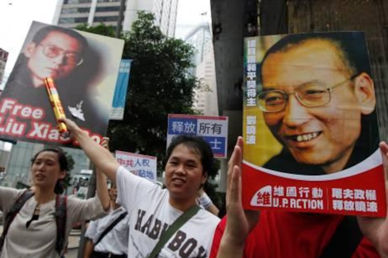 Pro-democracy protesters hold the picture of Chinese dissident Liu Xiaobo and words "Release Liu Xiaobo" as they march to the China's Liaison Office in Hong Kong Sunday, Oct. 10, 2010. Awarding the Nobel Peace Prize to the imprisoned Liu sparked praise from Western governments, brought condemnation from Beijing and is exposing the difficulties fitting a powerful, authoritarian China into the international order. (AP Photo/Kin Cheung) *** Local Caption ***  XKC103_Hong_Kong_Nobel_Peace_Prize.jpg