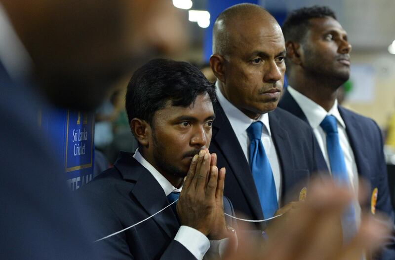 Sri Lankan cricketer Akila Dananjaya (L), Sri Lanka's cricket team captain Angelo Mathews (R) and Manager of the national team Charith Senanayake (C) look on as Buddhist monks chant prayers for their success during a Buddhist ceremony in Colombo on September 11, 2018, prior to the team's departure for a cricket tour in Dubai to participate in the Asia Cup Tournament from September 15 till September 28. (Photo by ISHARA S. KODIKARA / AFP)