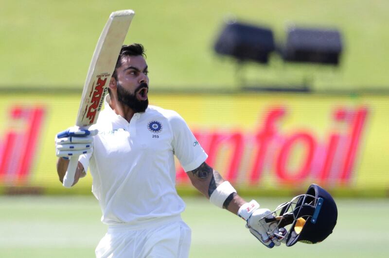 (FILES) This file photo taken on January 15, 2018 shows India's captain Virat Kohli raising his bat and helmet as he celebrates scoring a century (100 runs) during the third day of the second Test cricket match between South Africa and India at Supersport cricket ground in Centurion. 
Kohli on January 18 was crowned cricketer of the year by the sport's world governing body, capping off a strong innings for the Indian skipper across all three formats. / AFP PHOTO / GIANLUIGI GUERCIA