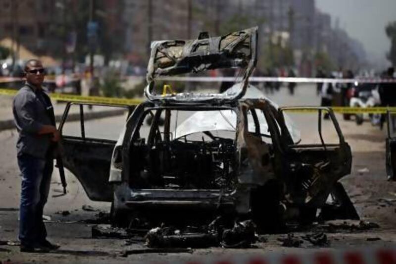 Egyptian security personnel gather at the scene of a bomb attack targeting the convoy of Egypt's interior minister Mohammed Ibrahim, in Nasr City, Cairo.