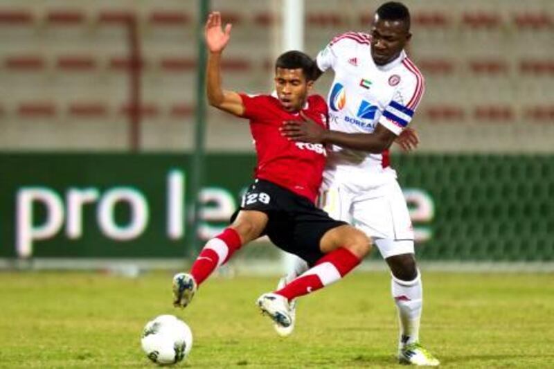 Al Ahli's Ali Hussain, 29, is tackled by Al Jazira's Diaky Ibrahim during the first half of their round 12 Etisalat Pro-League match at Rashid Stadium in Dubai on January 22, 2012. Christopher Pike / The National