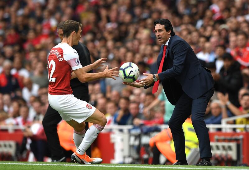 LONDON, ENGLAND - AUGUST 12:  Unai Emery, Manager of Arsenal passes the ball to Stephan Lichtsteiner of Arsenal during the Premier League match between Arsenal FC and Manchester City at Emirates Stadium on August 12, 2018 in London, United Kingdom.  (Photo by Shaun Botterill/Getty Images)