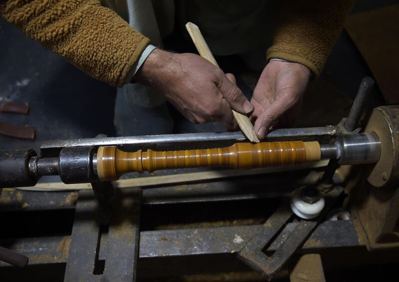 An artisan works on a machine to make a set of bagpipes. Rosewood or ebony serve as the blowstick, into which players exhale. The drones - long pipes with a lower tone - follow a similar process. AFP.