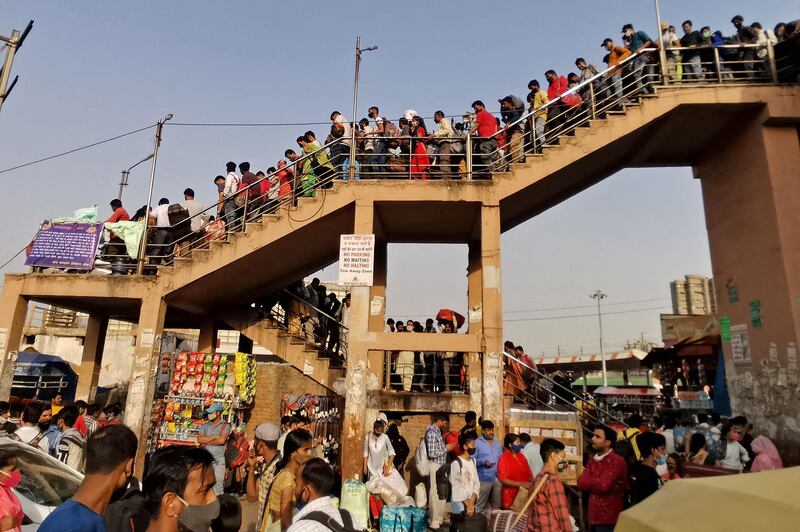 People crowd at a bus station to leave for their native places hours before a week-long lockdown in New Delhi, India comes into effect. AFP