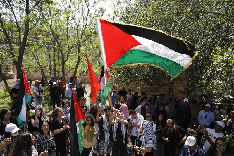 Arab Israelis protestors hold up the Palestinian flag in the village of Hittin as they march for the right of return for Palestinian refugees who fled their homes or were expelled during the 1948 war that followed the creation of the state of Israel, near Tiberias in northern Israel, on April 15, 2021. Israelis are marking Independence Day, celebrating the 73th year since the founding of the Jewish State in 1948 according to the Jewish calendar. / AFP / Ahmad GHARABLI
