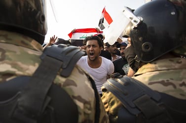 An Iraqi protestor gestures in front of security forces during a demonstration against state corruption, failing public services and unemployment in the southern city of Basra. AFP 
