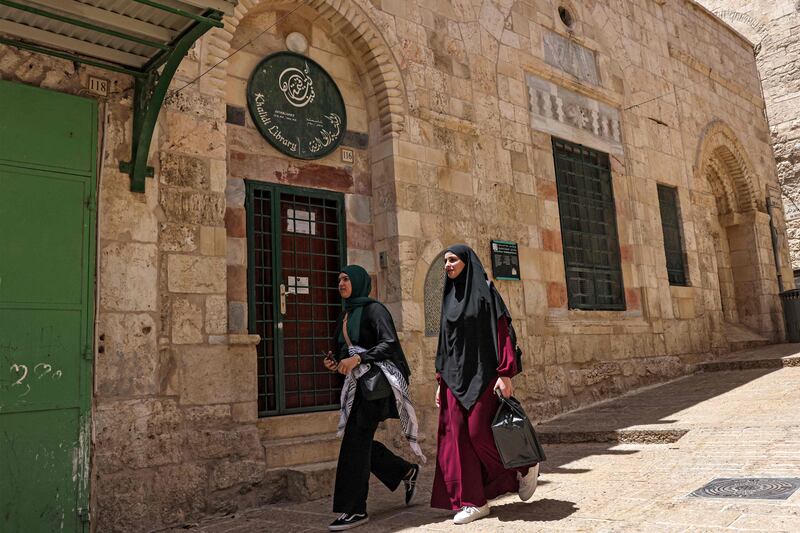 Palestinians walk past the Khalidi library at the old city of Jerusalem on June 17, 2023.  Located in the walled Old City near an entrance to the Al Aqsa mosque complex, the library was founded by Palestinian notable Raghib Al-Khalidi in 1900 at the request of his late mother Khadija.  It also holds Persian, German and French books, including an impressive collection of 60 titles by Victor Hugo.  Its founder studied at the Sorbonne in Paris.  (Photo by AHMAD GHARABLI  /  AFP)