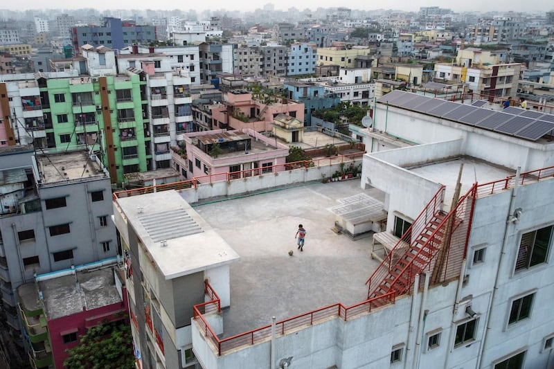 This picture taken on March 23, 2020 shows Samin Sharar, 9, playing on the rooftop of his building in Dhaka, as he avoids going out due to fears over the COVID-19 novel coronavirus. / AFP / Munir UZ ZAMAN
