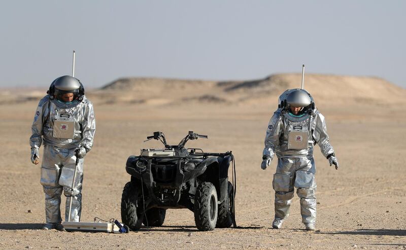 Members of the AMADEE-18 Mars simulation mission wear spacesuits while conducting scientific experiments next to an all-terrain vehicle in Oman's Dhofar desert. Karim Sahib / AFP Photo