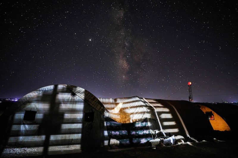 This long-exposure picture taken early shows a view of the Milky Way galaxy rising in the sky above the Ahl al-Tah camp for displaced persons near the town of Maaret Misrin in Syria's northwestern Idlib province.  AFP