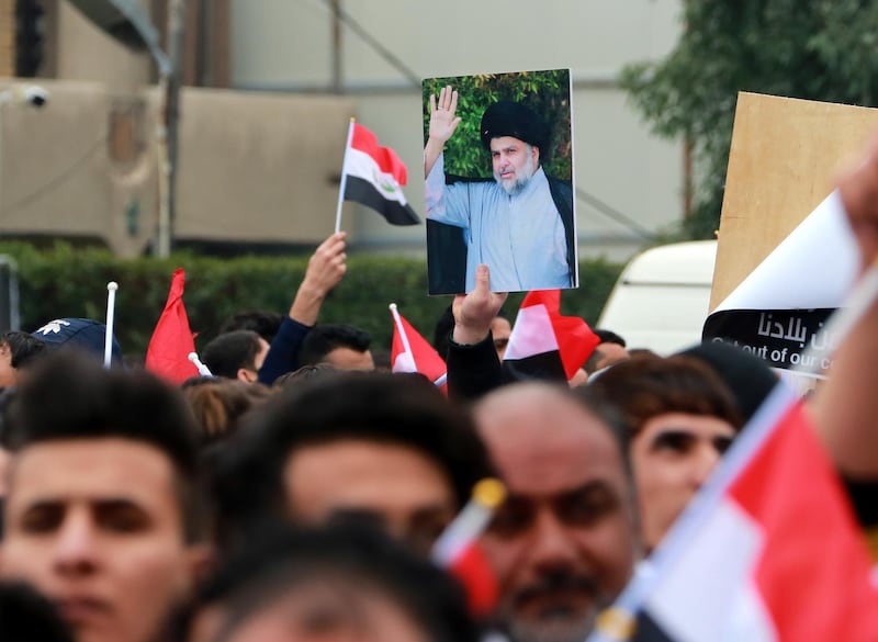 Supporters of Moqtada Al Sadr chant slogans and carry his picture during a demonstration. EPA