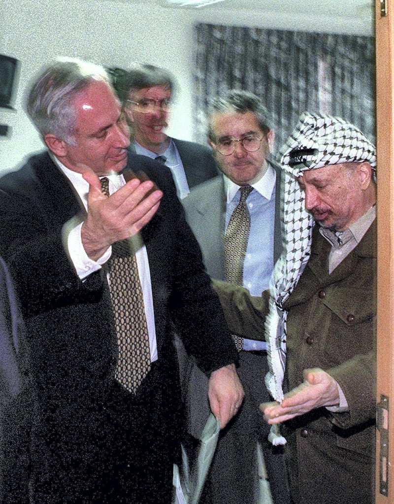 Palestinian President Yasser Arafat (R) and Israeli Prime Minister Benjamin Netanyahu both gesture for the other to leave a meeting December 24 in the Israeli Civil Administration headquarters located along the Israeli - Gaza Strip border area. The two leaders met for for over three hours in a bid to clinch the agreement on the long-delayed Israeli troop redeployment in Hebron. Although no agreement was reached U.S. envoy Dennis-Ross said that "real progress" was made towards the long-elusive accord.