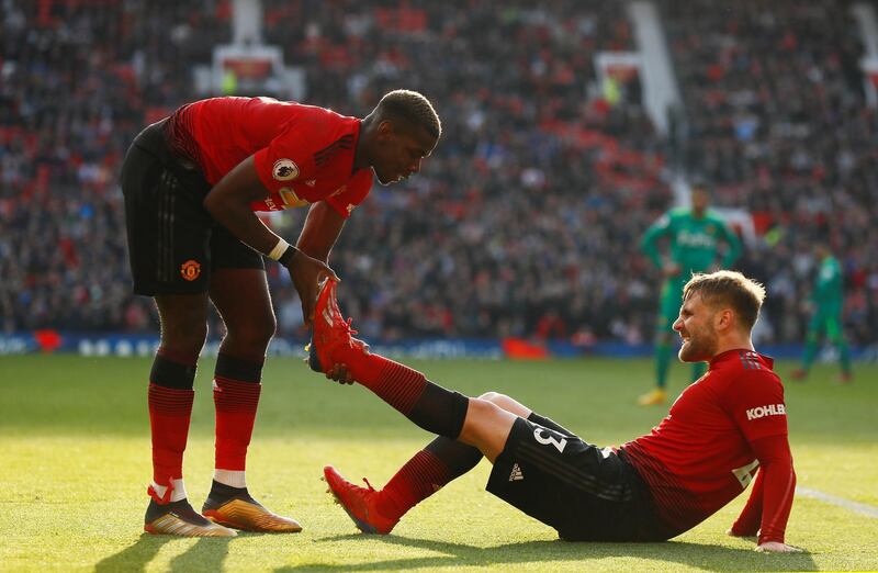 Paul Pogba helps Luke Shaw deal with cramp in the late stages of the game. Action Images via Reuters